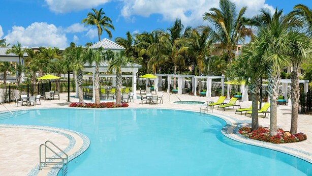 A swimming pool with lounge chairs and palm trees. - Hilton Garden Inn Key West / The Keys Collection (Key West)