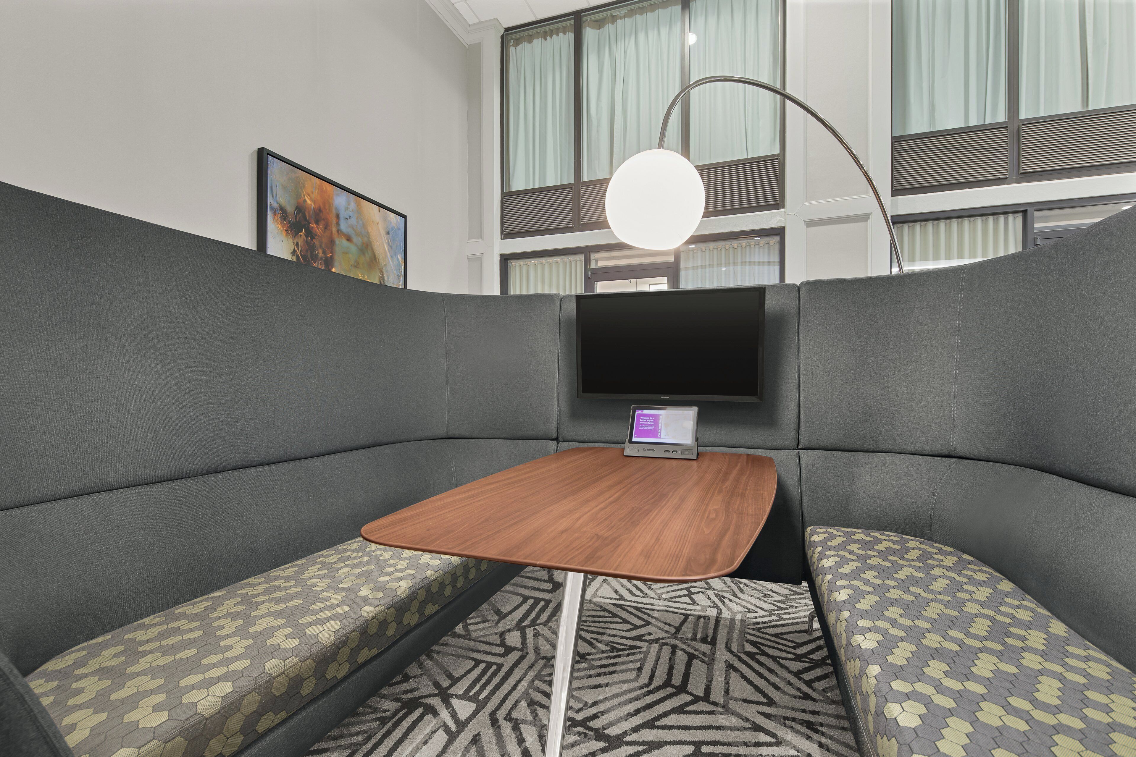 Ein modernes Zimmer mit einem Ecksofa, einem kleinen Holztisch und einem Flachbildfernseher.