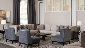 A modern living room with a sofa, armchairs, a coffee table, and a patterned rug. - Crowne Plaza Hotel Greenville-I-385-Roper Mtn Rd by IHG (Greenville)