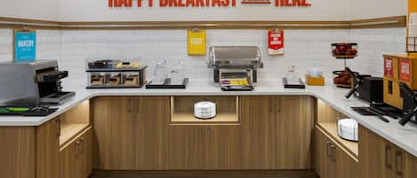 A breakfast station with a sign that reads 'HAPPY BREAKFAST STARTS HERE.'