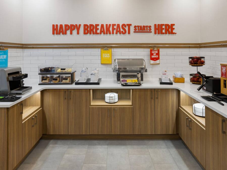 A breakfast station with a sign that reads 'HAPPY BREAKFAST STARTS HERE.'