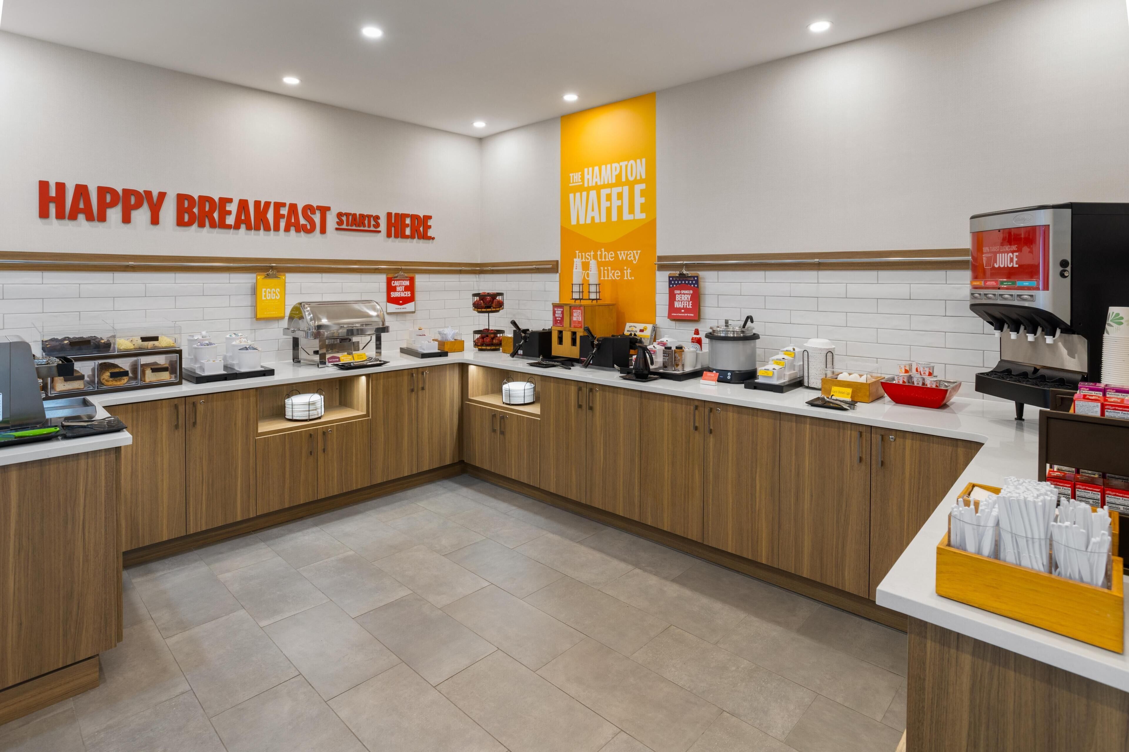 Ein Frühstücksbereich mit einem Schild, auf dem steht: 'HAPPY BREAKFAST STARTS HERE'.