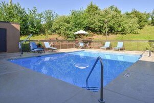 Una piscina al aire libre de temporada, sombrillas