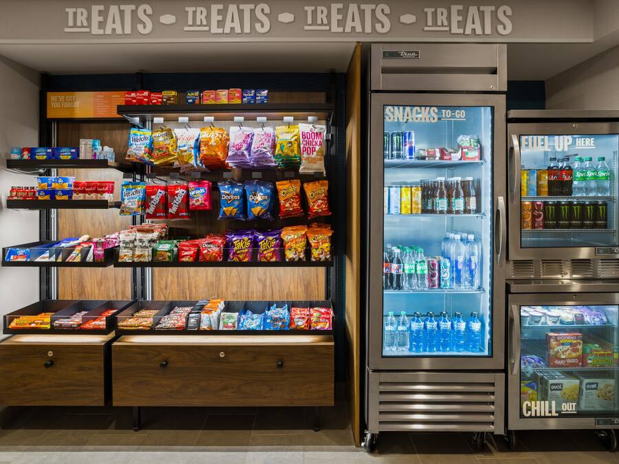 Zona de venta de aperitivos con diversas opciones de bocadillos y un dispensador de bebidas.