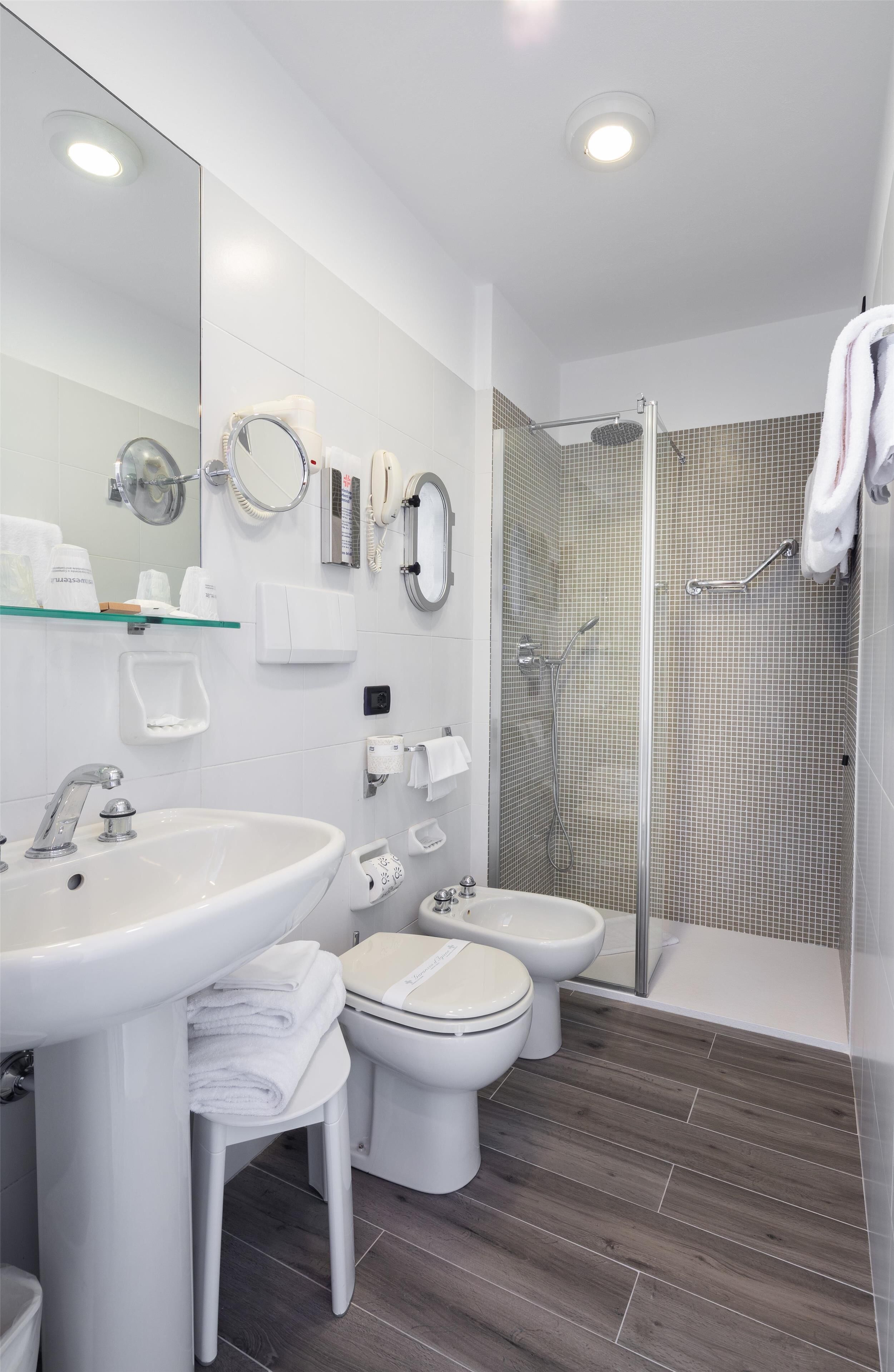 Un baño moderno con lavamanos, inodoro, bidé y ducha.