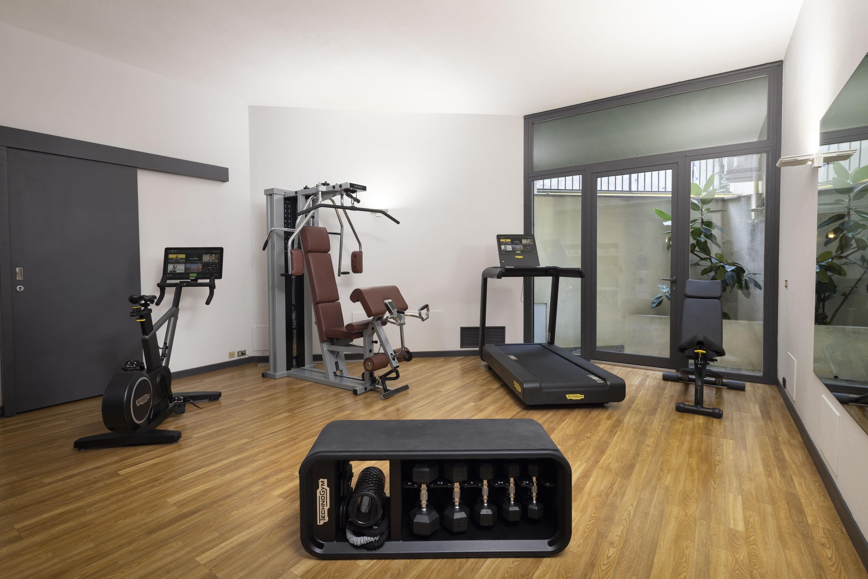 A gym with exercise equipment including a treadmill, stationary bikes, and weight machines.