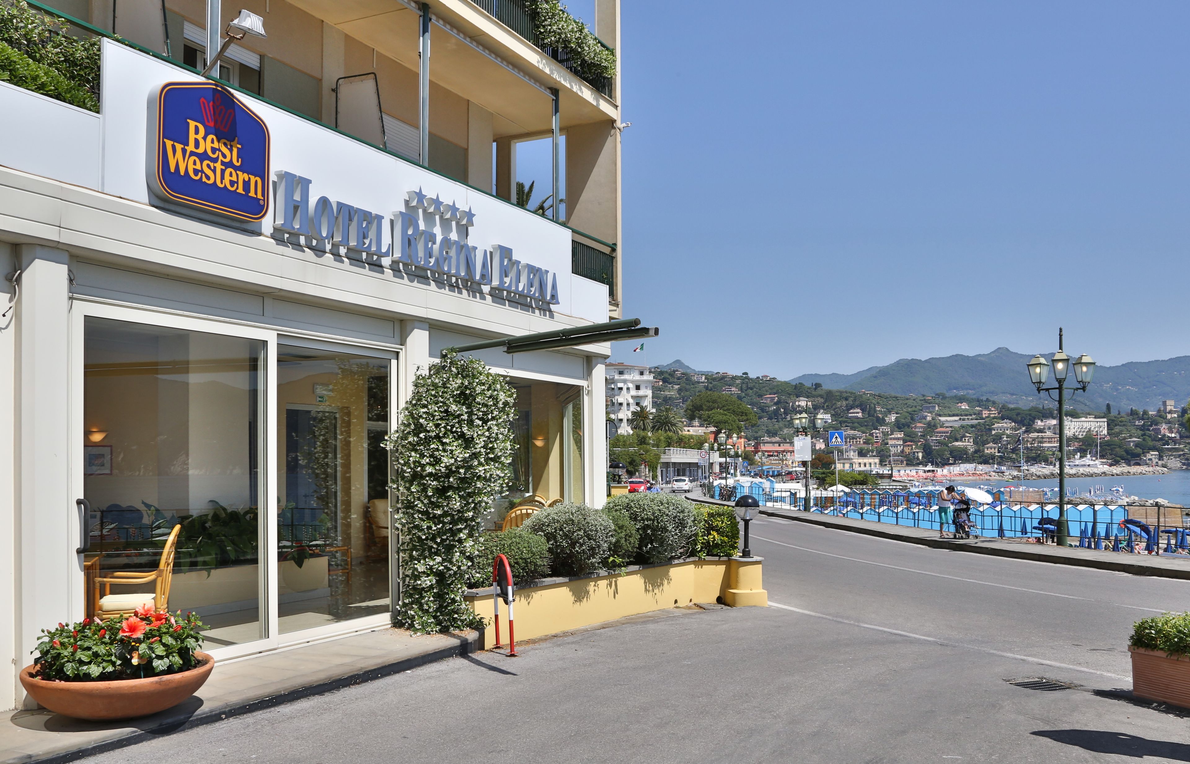 A hotel with a balcony, large windows, and a view of the sea.