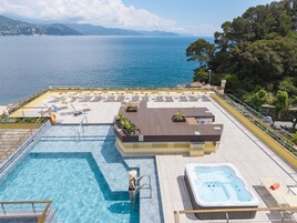 Una piscina al aire libre, sillones reclinables de piscina