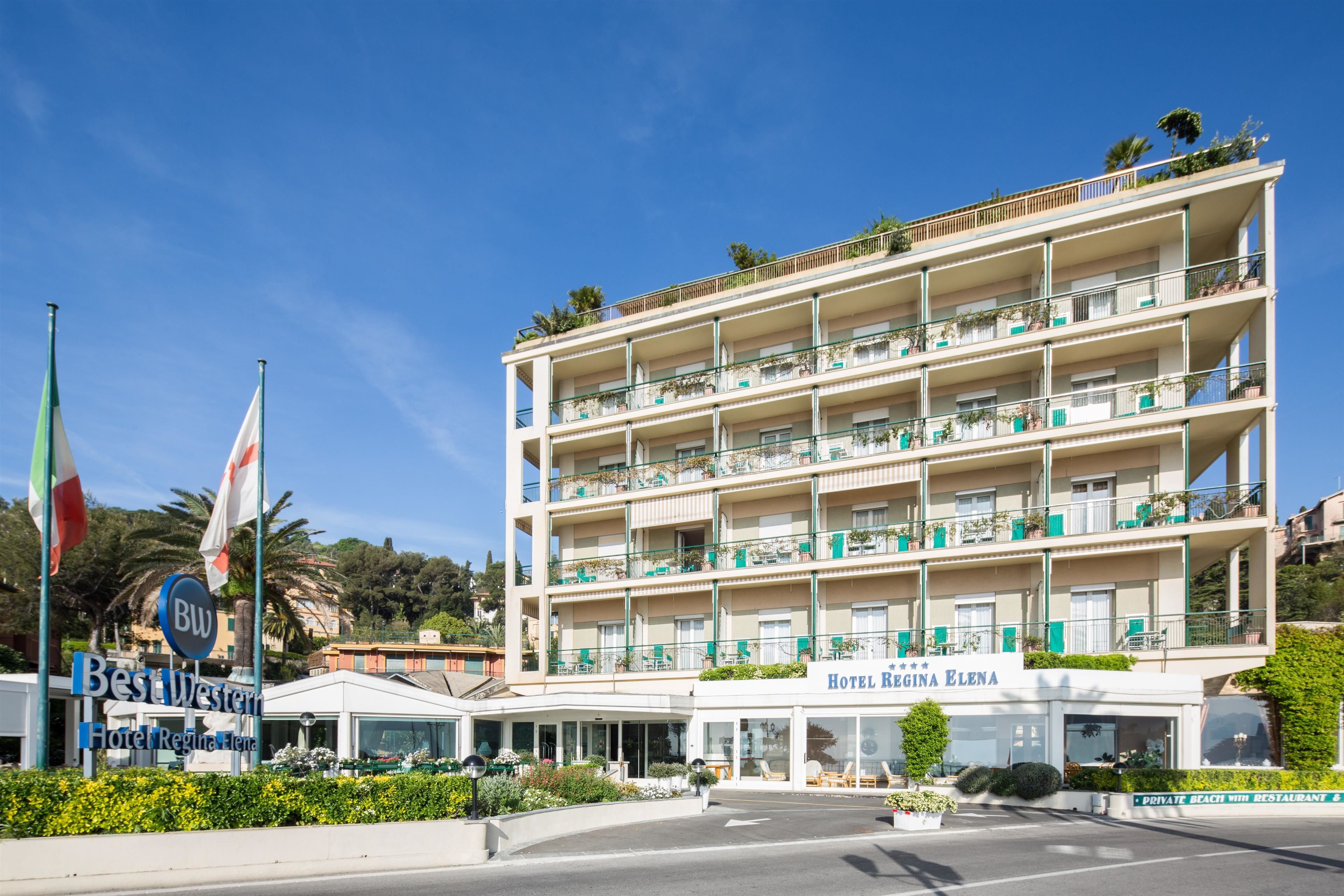 Un hotel de varios pisos con balcones, un cartel de Best Western Hotel Regina Elena y una playa privada con restaurante al aire libre.