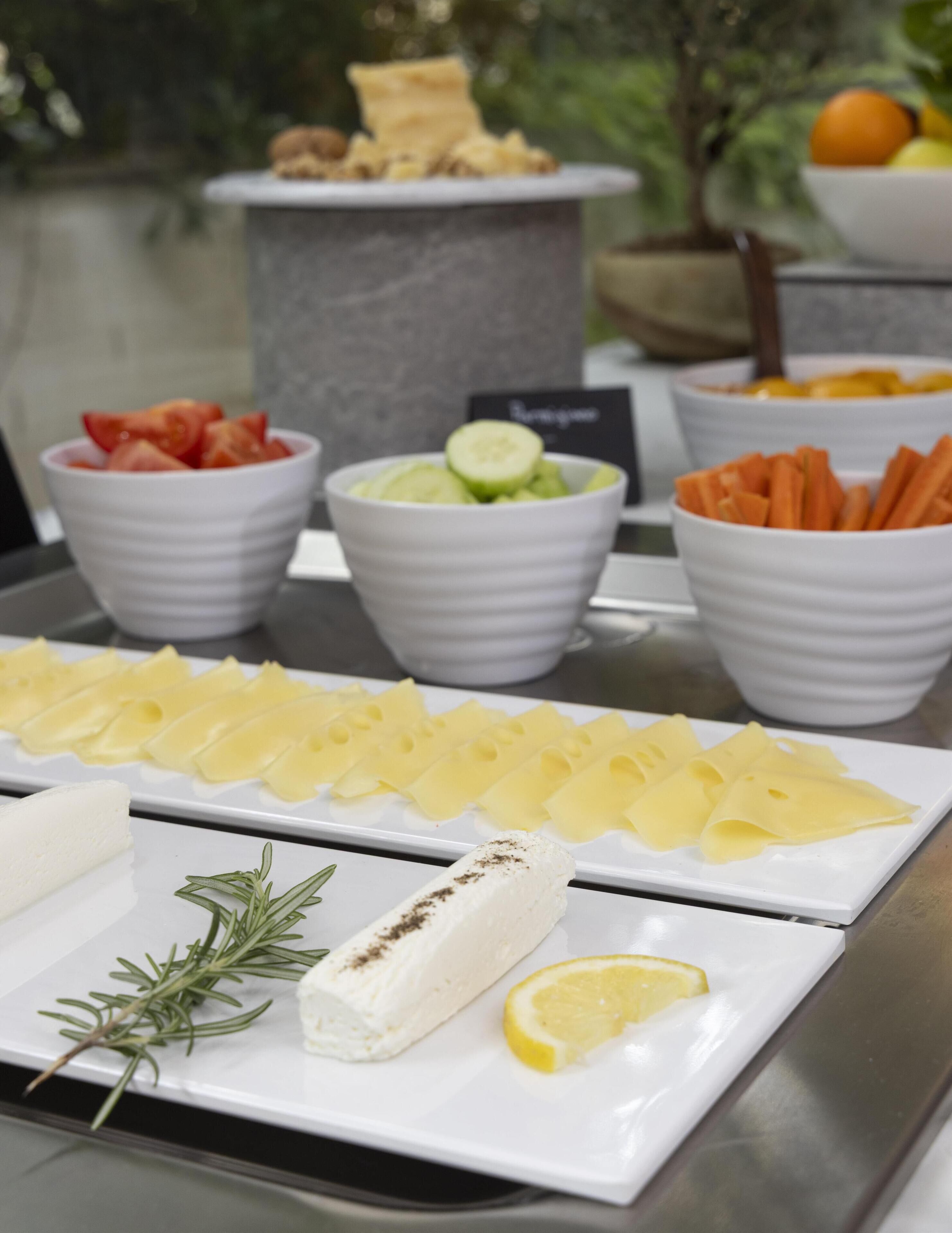 Een buffet met diverse soorten eten, zoals gesneden fruit, groenten en kaas.