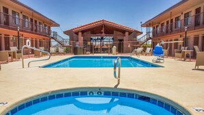 Area piscina con lettini e zona relax coperta.