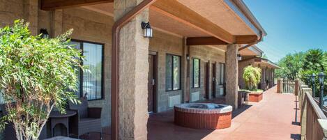 A covered outdoor area with stone walls, seating, and planters.