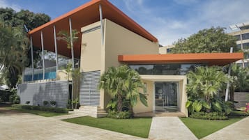 Um edifício moderno com telhado plano, grandes janelas e entrada coberta.