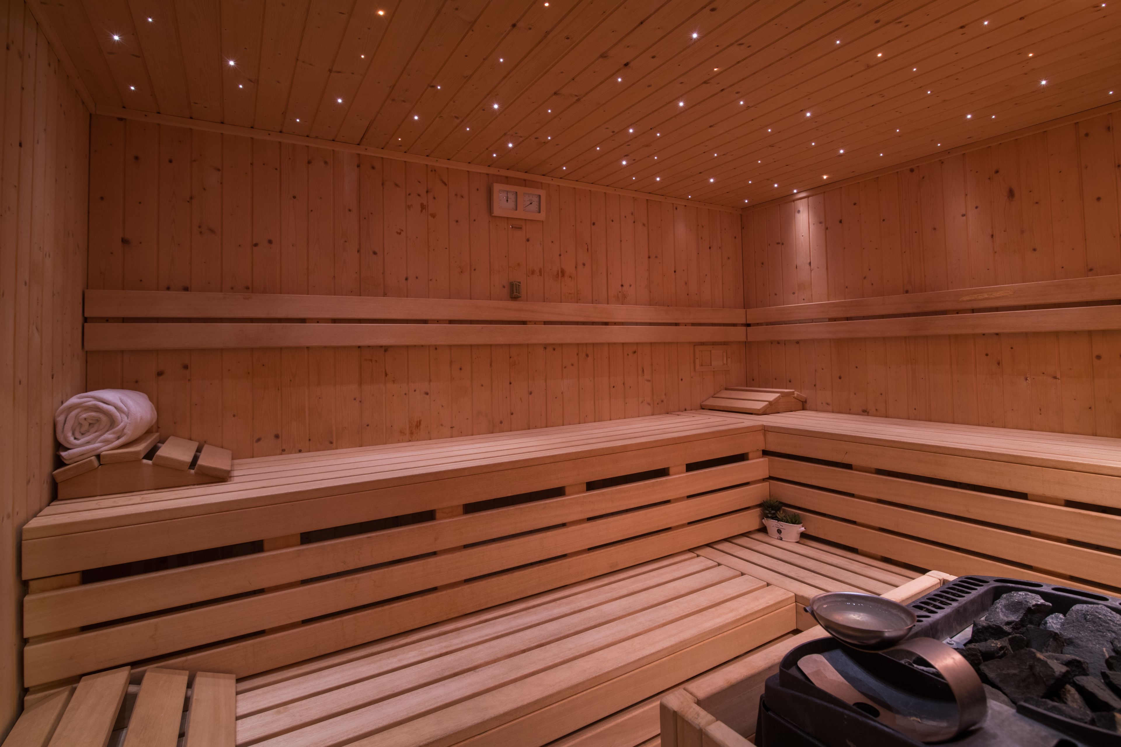 A wooden sauna with benches and a sauna table.