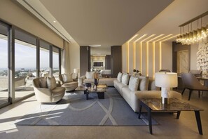 A modern living room with a sofa set, a coffee table, and a dining area with a chandelier. - El Embajador, a Royal Hideaway Hotel (Santo Domingo)