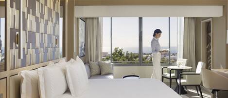 A hotel room with a large bed, a desk, and a view of the city.