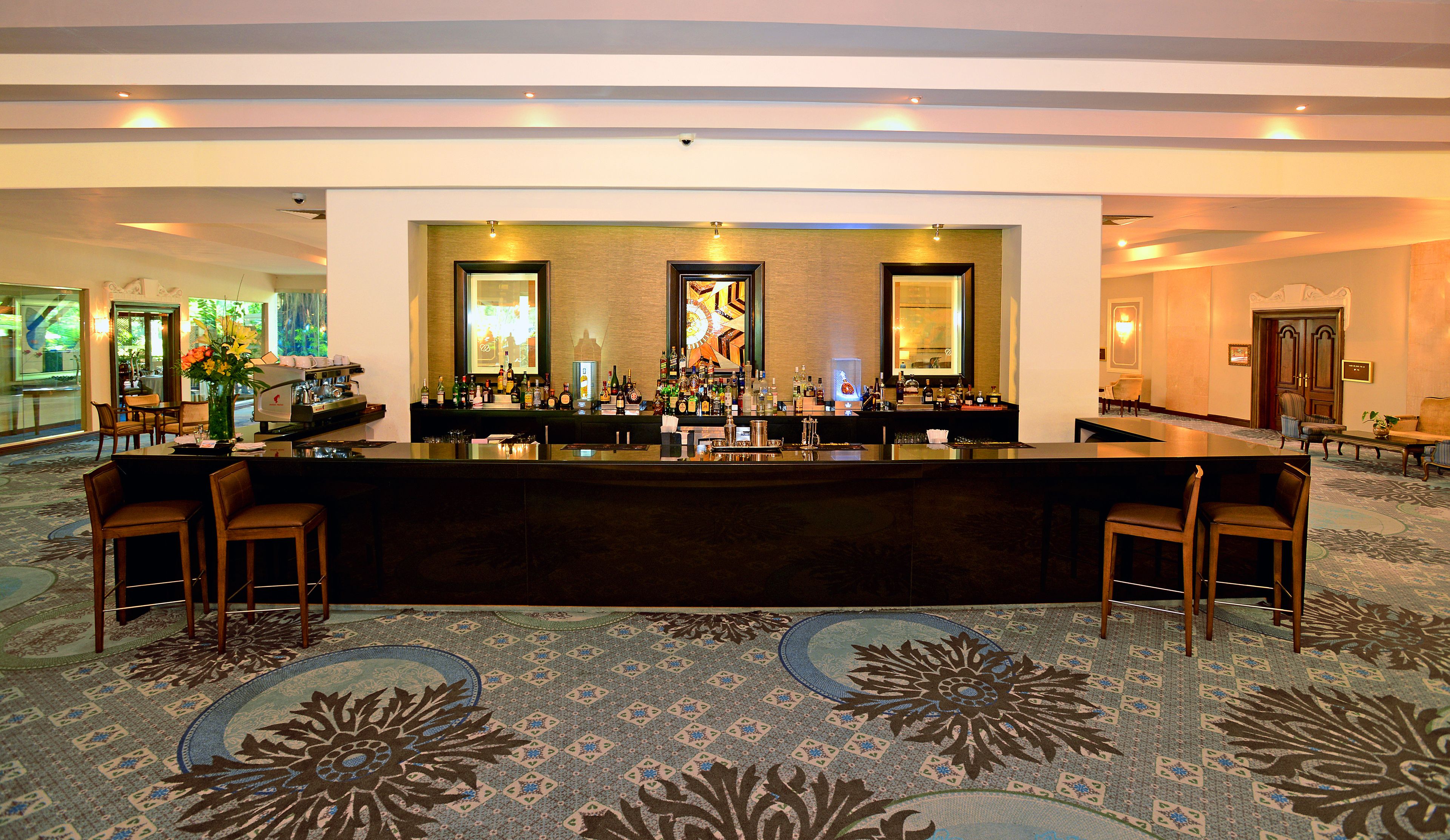 A hotel lobby with a reception desk, bar area, and seating.