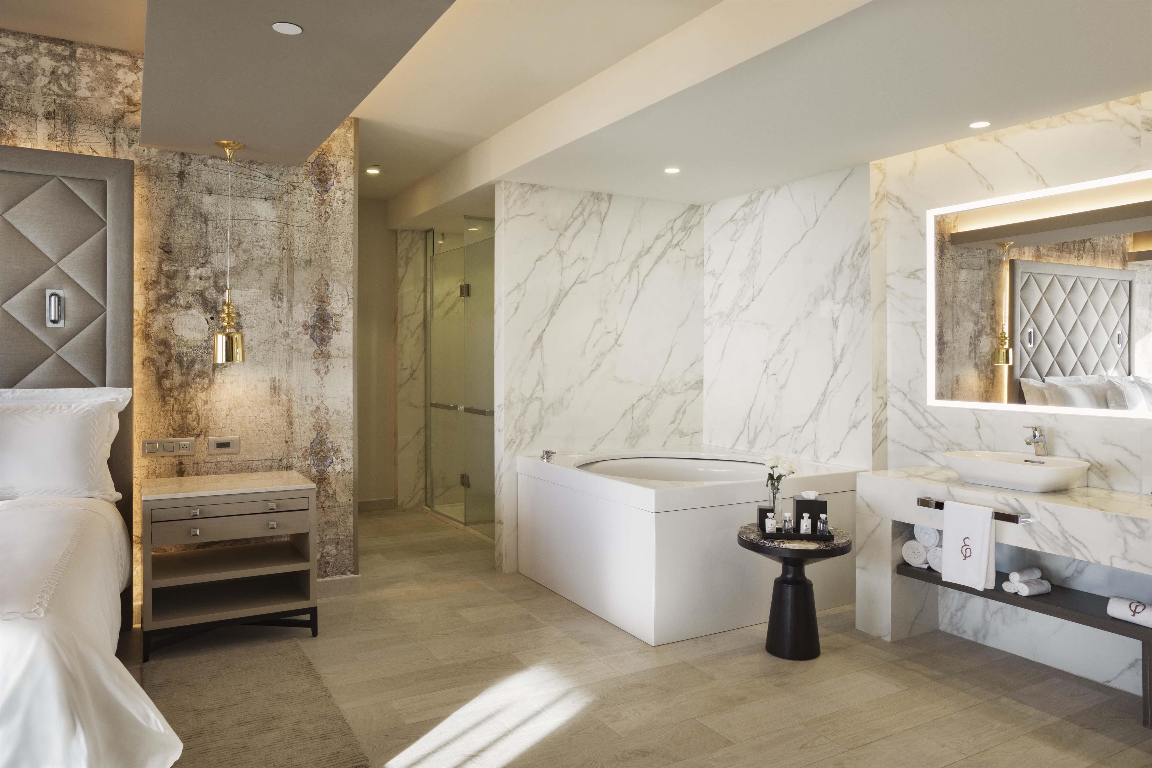 A modern bathroom with a marble vanity, a freestanding bathtub, and a shower area.