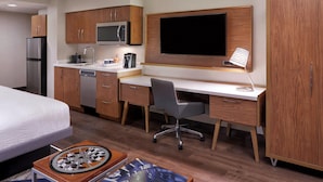 A compact hotel room with a kitchenette, a bed, a desk with a chair, and a TV. - Four Points by Sheraton Hamilton - Stoney Creek (Hamilton)