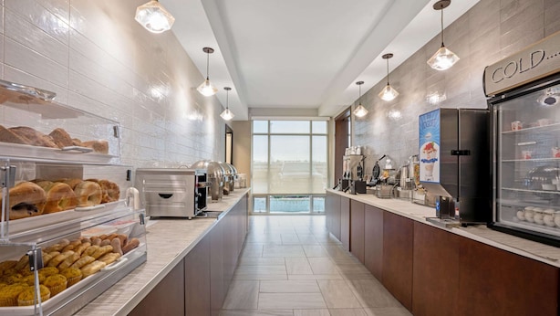 A modern breakfast area with a self-serve station, refrigerated display, and a view through the window. - La Quinta Inn & Suites by Wyndham Seattle Federal Way (Federal Way)