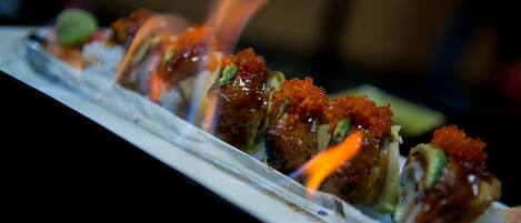 A sushi dish with a flame on top.