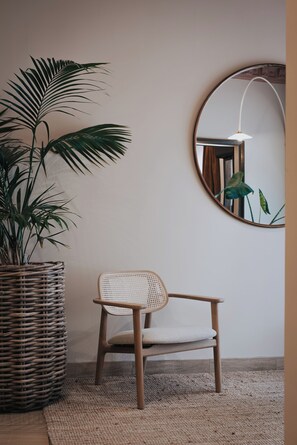 A wicker chair with a woven seat and backrest, positioned on a textured rug.