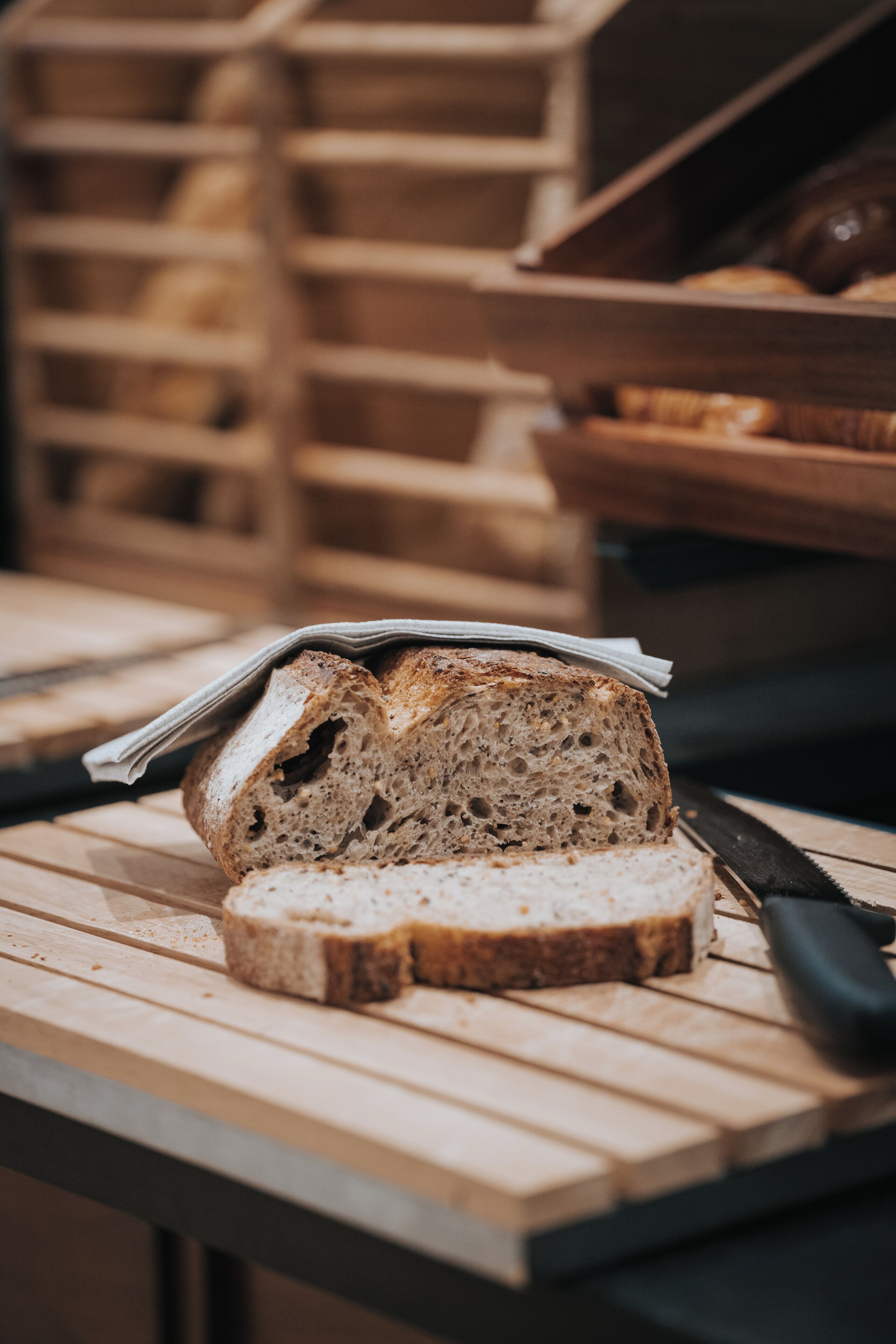 A loaf of sliced bread on a wooden cutting board with a knife beside it.