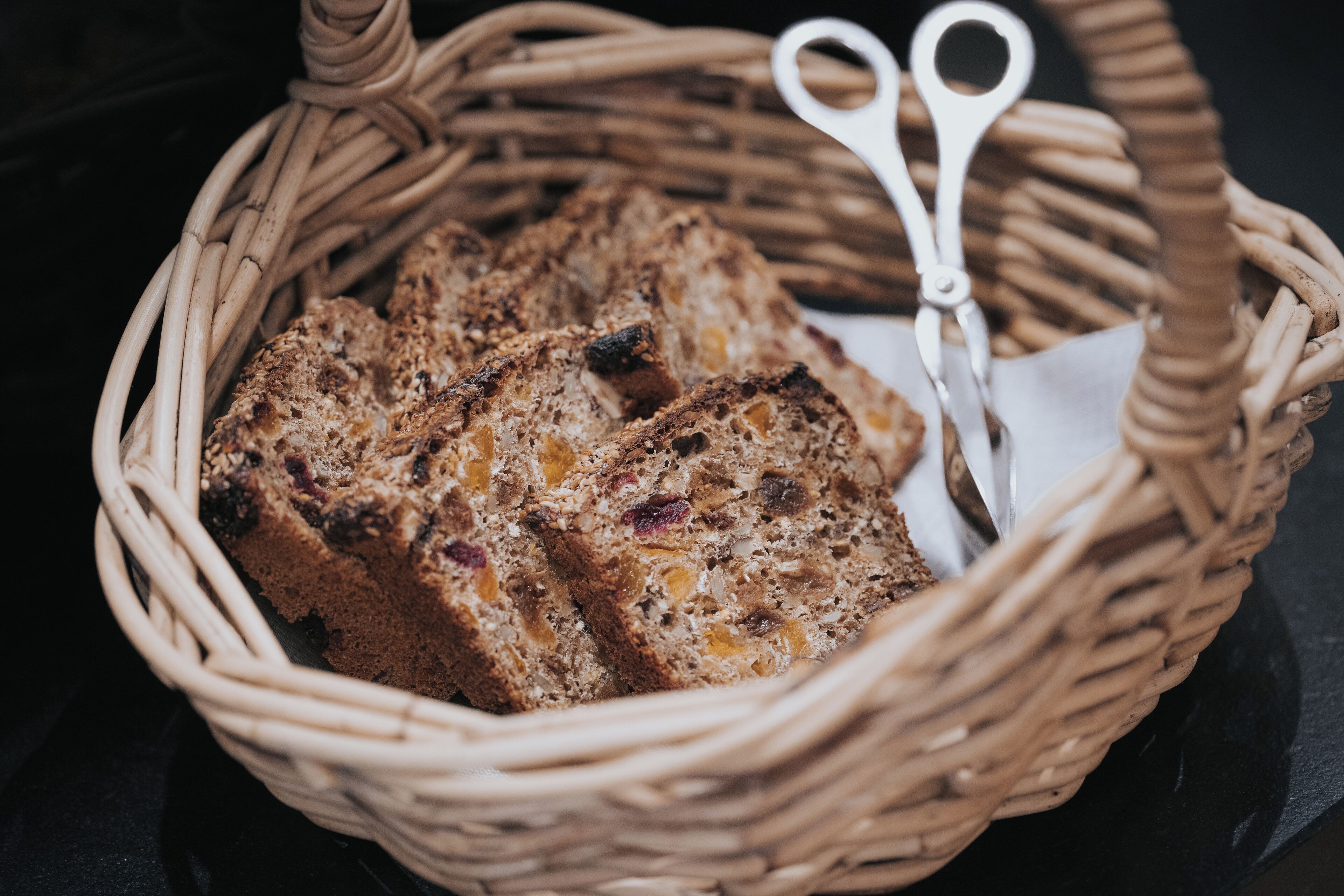Ein Korbbarn mit Brotscheiben und einer Schere darauf.
