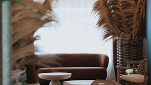 A modern interior with a sofa, round tables, and chairs.