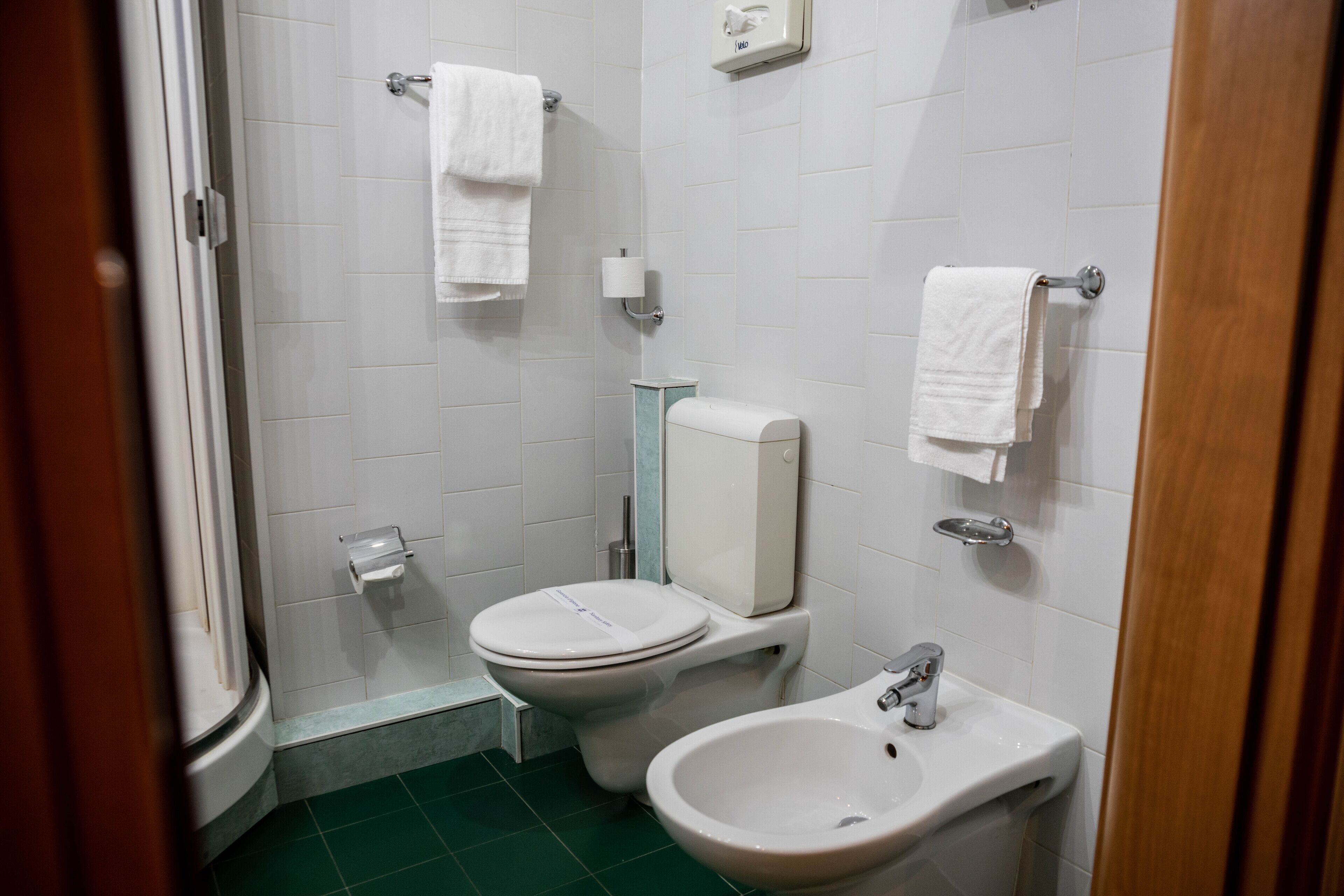 A small bathroom with a toilet, bidet, and sink.