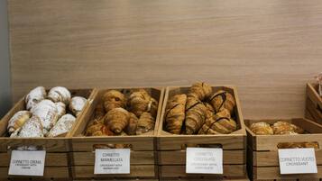 Holzvitrinen mit verschiedenen Croissant-Sorten, beschriftet mit ihren Namen.
