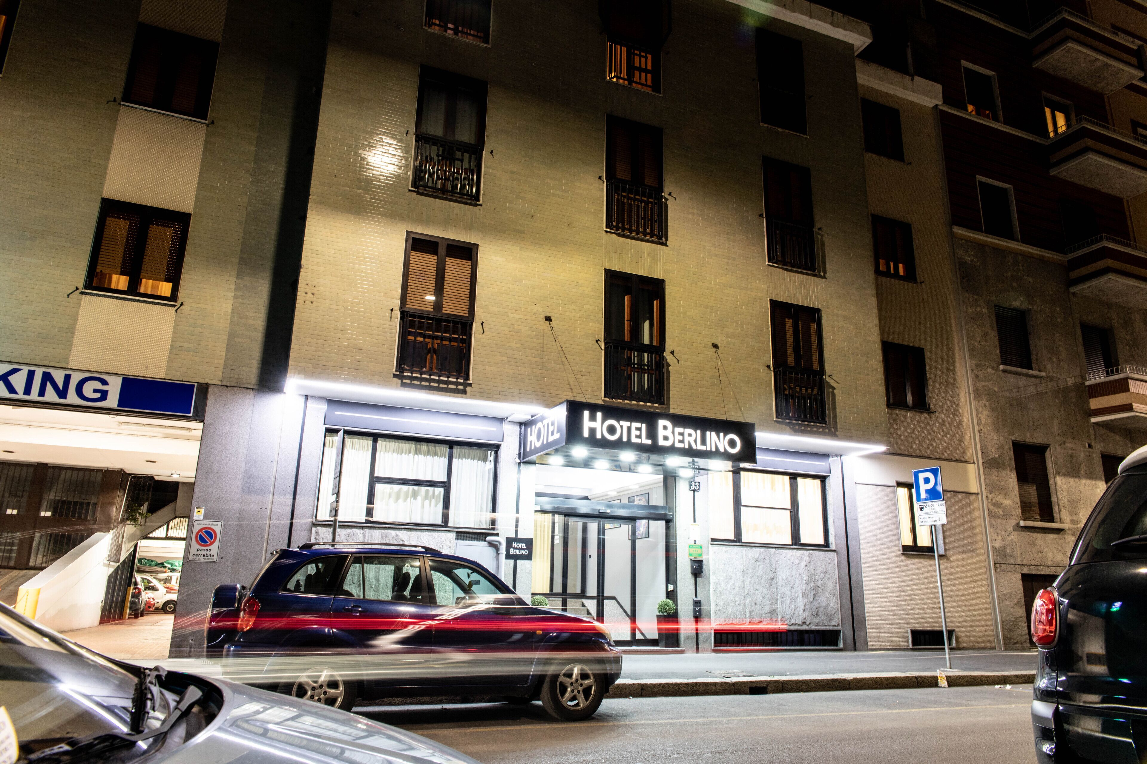 En hotellbyggnad med en skylt som visar texten ”Hotel Berlino” och en parkeringsskylt.