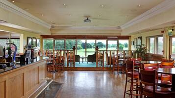 Un'ampia area interna con una reception, diverse zone relax e ampie finestre vista all'esterno.