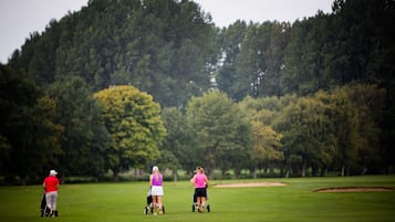 Golfers enjoy a serene round amidst lush greenery and dense trees.