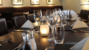 A dining table set with multiple wine glasses, a candle, and cutlery. - Barnham Broom Hotel, Golf & Spa (Norwich)