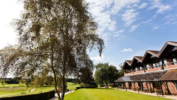 A building with a large lawn, a tree, and a clear sky. - Barnham Broom Hotel, Golf & Spa (Norwich)