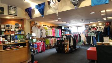 A clothing store with racks of shirts and pants, a display of shoes, and a 'No Smoking' sign.