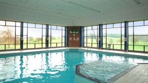An indoor swimming pool with clear views of a green landscape through large windows. - Barnham Broom Hotel, Golf & Spa (Norwich)