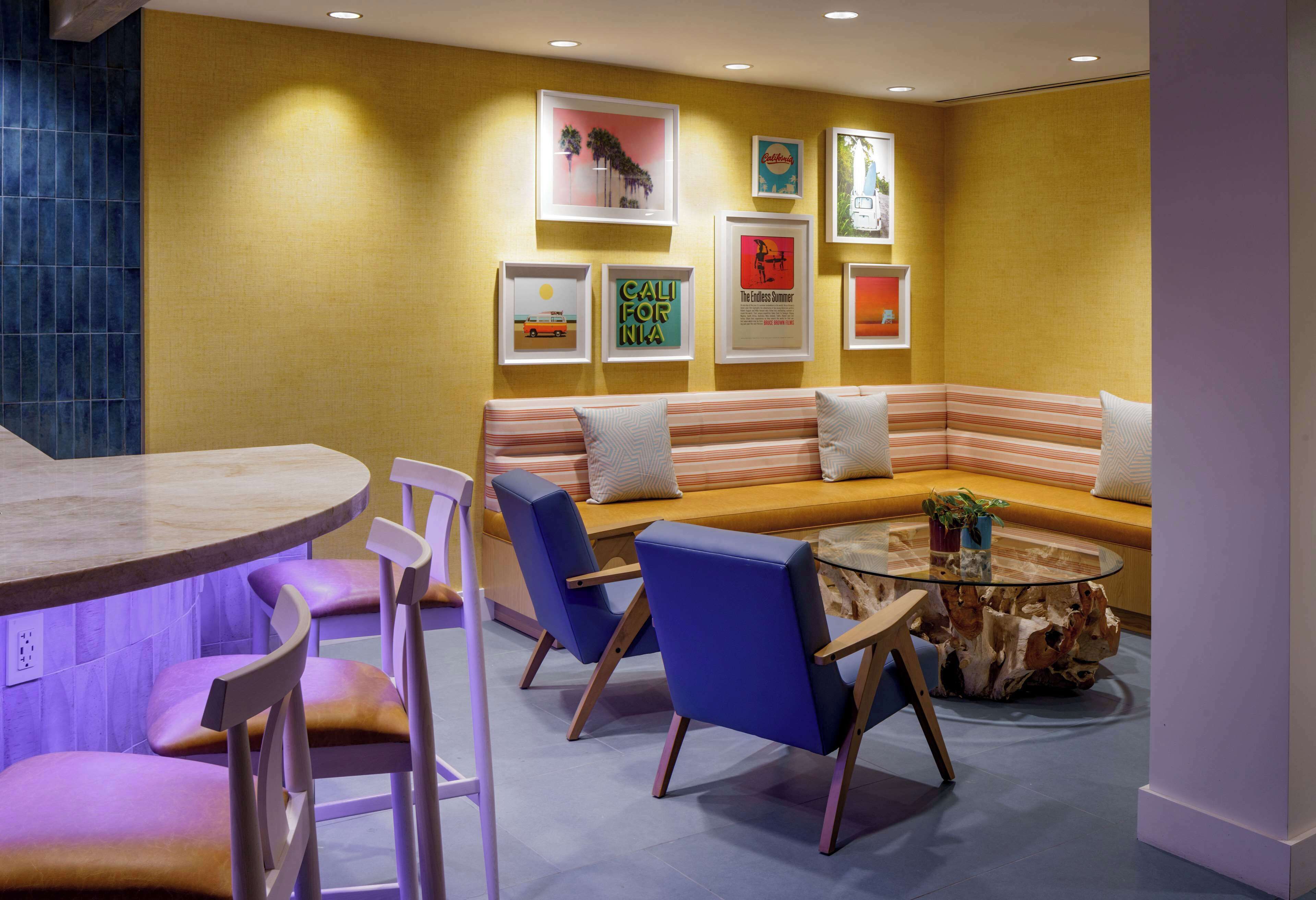 A modern lounge area with a sofa, chairs, and a glass coffee table.