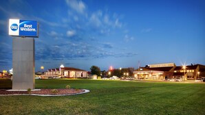 A Best Western hotel with a large sign, multiple buildings, and a well-maintained lawn.