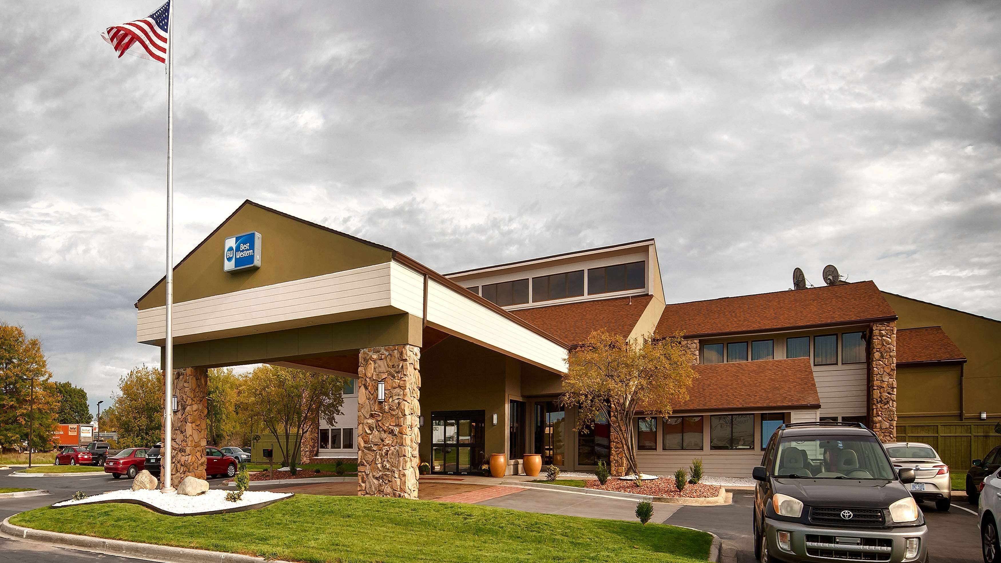Un hotel Best Western con facciata in pietra, ingresso coperto e parcheggio.