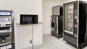 A room with a black refrigerator, a microwave, and an ATM. - Dallas Love Field Inn (Dallas)