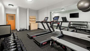 A gym with treadmills, dumbbells, and a bench. - Spark by Hilton Moline Quad Cities (Moline)
