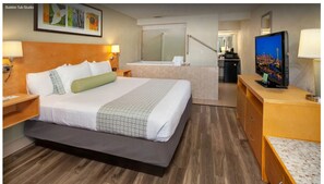 A hotel room with a bed, a TV, a desk, a mirror, and a bathroom visible through an open door. - Hotel Nexus, BW Signature Collection (Seattle)