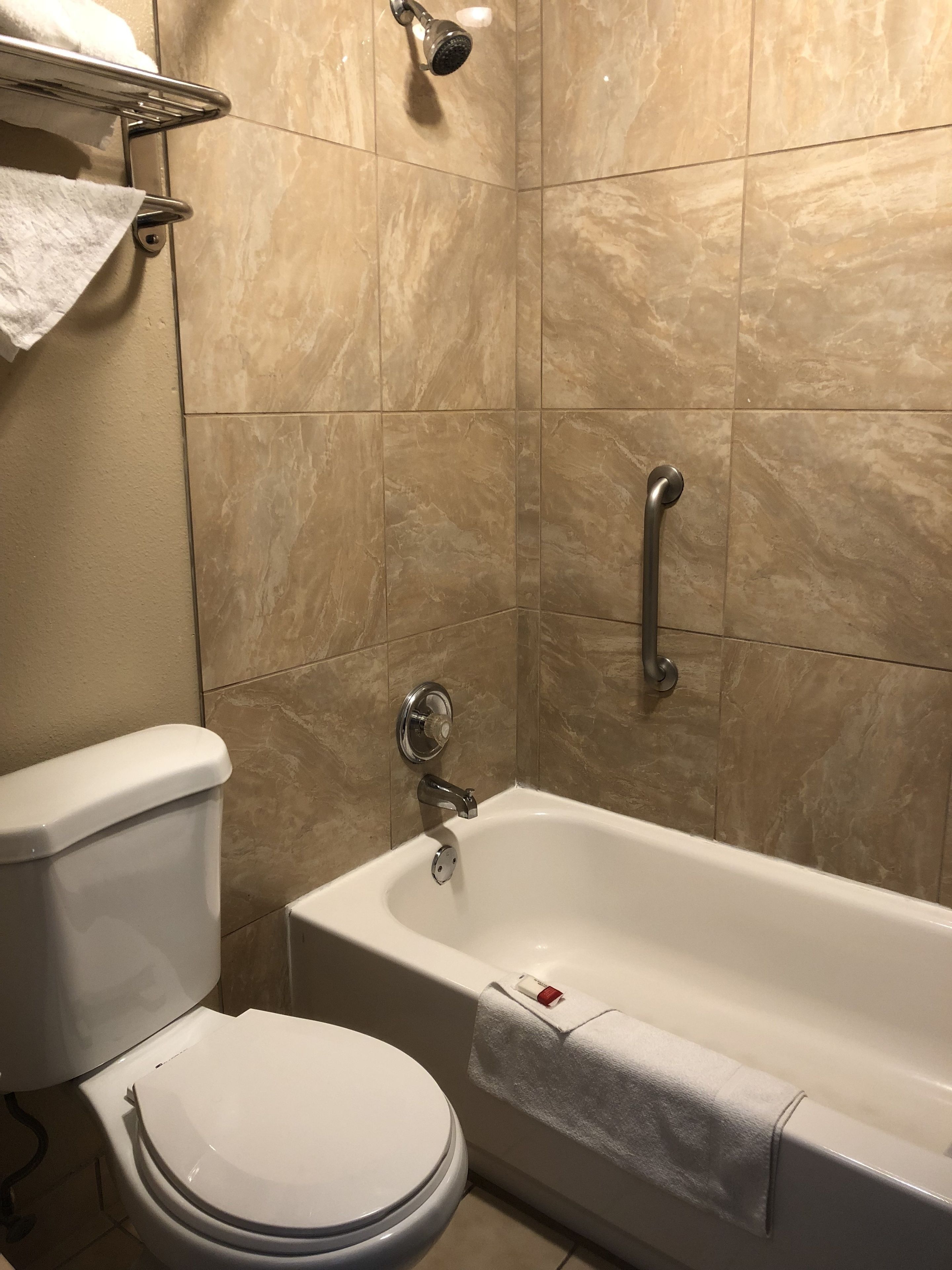 Ein Badezimmer mit Toilette, Badewanne und Duschkopf.
