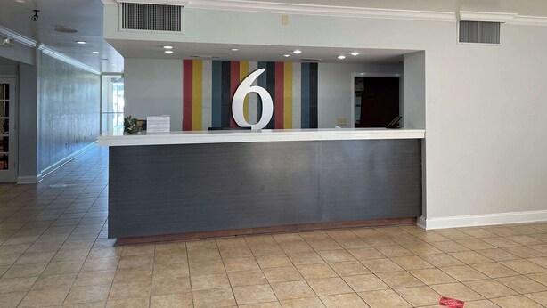 Un área de recepción con un gran letrero con el número 6, un diseño moderno y un piso de baldosas.