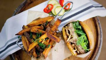 A meal consisting of fries and a sandwich on a wooden tray.