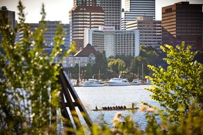 A cityscape with a prominent Marriott hotel, a river with boats, and a bridge in the foreground.