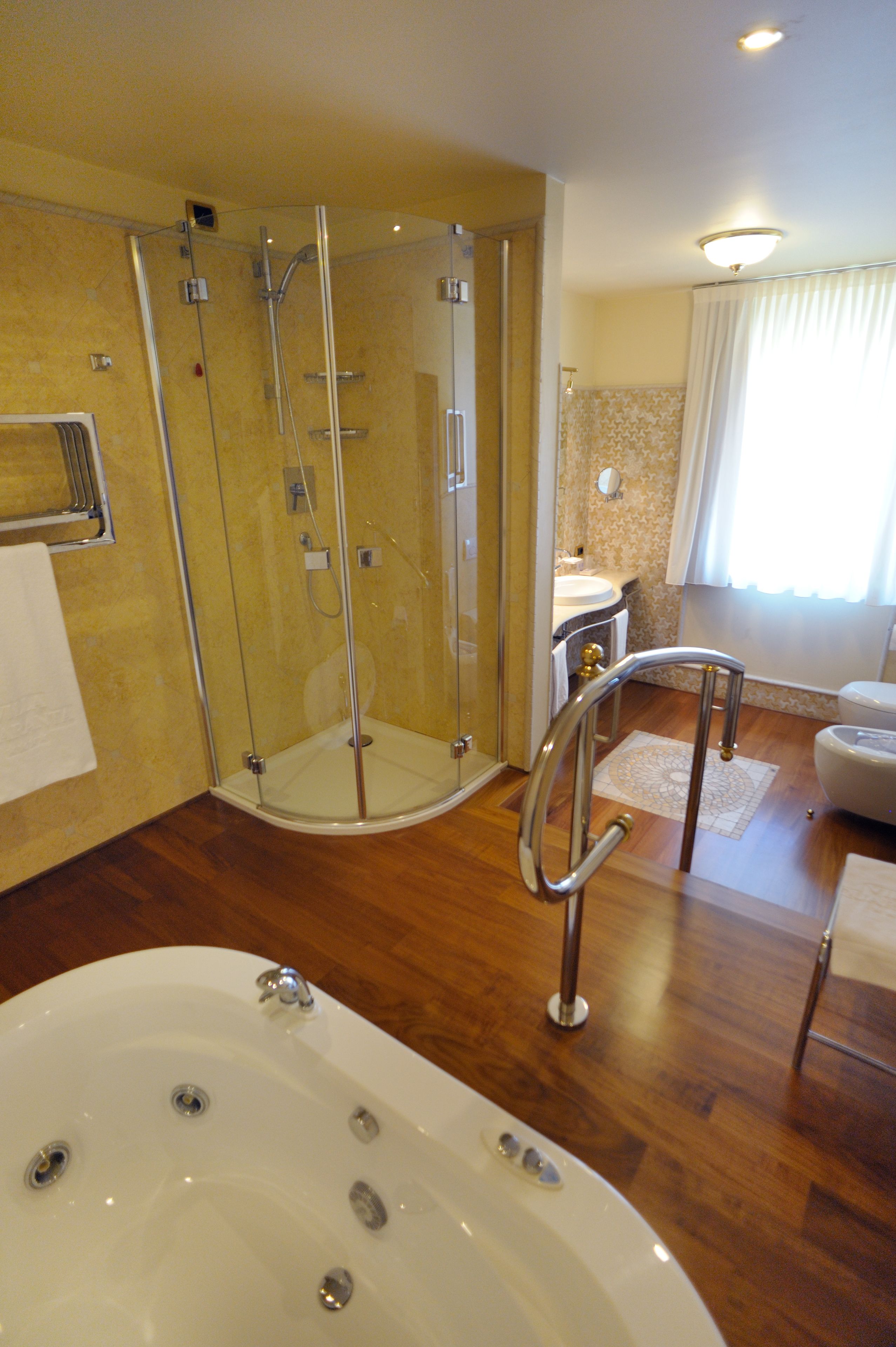 Un baño con ducha envuelta en cristal, bañera y lavabo.