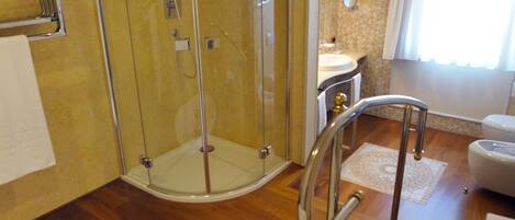 A bathroom with a glass-enclosed shower, a bathtub, and a sink.